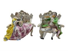 Pair of Hochst porcelain figures modelled as a male and female figure seated on an ornate sofa playi
