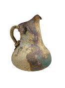 A studio pottery hand-built ewer with rope-twist handle and textured glaze