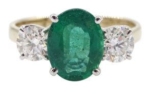 18ct gold three stone oval emerald and round brilliant cut diamond ring