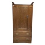 Oak wardrobe with one panelled door opening to reveal interior fitted for hanging with a falling sid