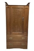 Oak wardrobe with one panelled door opening to reveal interior fitted for hanging with a falling sid