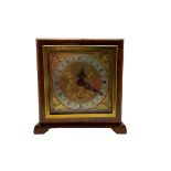 A compact mid-20th century English mantle clock in a square walnut case on raised feet