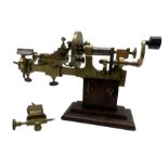 An early19th century hand operated brass watchmakers lathe in stained pine case