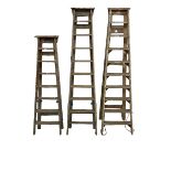A set of three vintage pine step ladders