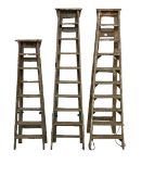 A set of three vintage pine step ladders