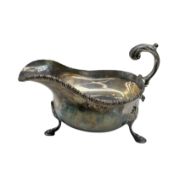Georgian design silver sauce boat with gadrooned edge and leaf capped scroll handle on hoof feet Lon