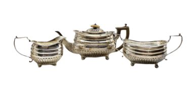 George III silver three piece tea set of oval design with half body reeded decoration
