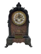 A late 19th century Belgium slate mantle clock with carved applied decoration to the arched top