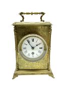 A French 19th century table clock in a decoratively engraved brass case on splayed bracket feet with