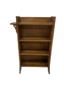 Oak bookshelf with three fixed shelves raised on panel end supports