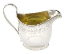 George III silver oval cream jug with engraved vacant cartouche and trailing foliate border with ree