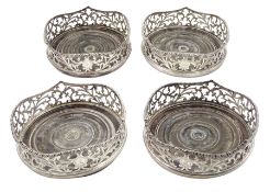 Set of four Victorian silver coasters with pierced sides engraved with a crest and with turned woode