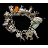 Silver charm bracelet with twenty six charms including clock