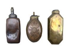 Two bottle shaped powder flasks in copper and brass and other powder flask of oval form