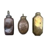 Two bottle shaped powder flasks in copper and brass and other powder flask of oval form