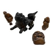 Small Japanese bronze lion with one raised paw L8cm and three 19th century carved wood netsukes