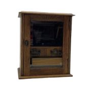 Early 20th century oak smokers cabinet with glazed hinged door enclosing two drawers and removable p