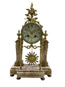 A late 19th century French portico clock on a break front variegated marble base with two conforming