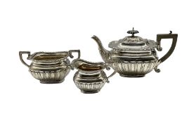 Edwardian silver three piece tea set of rectangular design with gadrooned edge and half body decorat