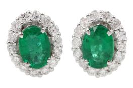 Pair of 18ct white gold oval emerald and round brilliant cut diamond cluster stud earrings