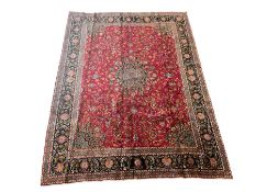 Persian rug with overall floral motifs on a red field and navy border 290cm x 400cm