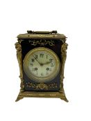 A French mantle clock c1900 in an ebonised case with brass mounts and carrying handle