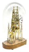 A 20th century seven pillar single train fusee skeleton clock with fretted triple spire movement pla