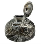 Edwardian silver overlaid circular glass inkwell decorated with panels of angels heads and with hing