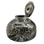 Edwardian silver overlaid circular glass inkwell decorated with panels of angels heads and with hing