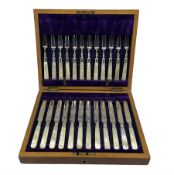 Set of twelve Edwardian dessert knives and forks with engraved silver blades and mother of pearl han