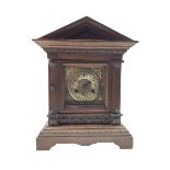 A German oak cased striking mantle clock with an architectural pediment
