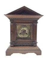 A German oak cased striking mantle clock with an architectural pediment