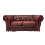 Two seat Chesterfield sofa upholstered in buttoned red leather