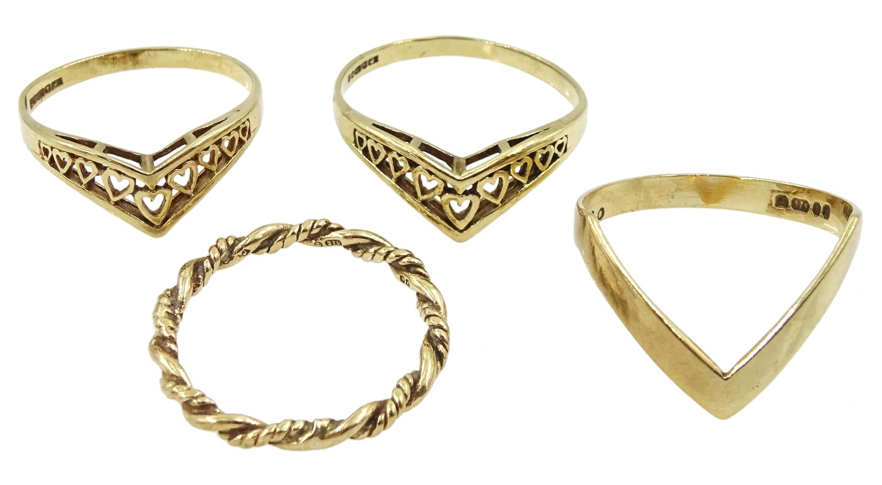 Three gold wishbone rings and one other gold twist ring