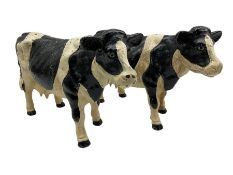 Pair of painted cast iron figures in the form of Friesian cows H21cm