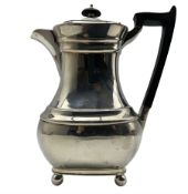 Silver hot water jug with ebonised handle and lift and on ball feet H24cm Sheffielfd 1936