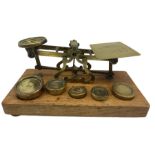 Set of brass postal scales by S Mordan & Co on an oak plinth and five brass weights