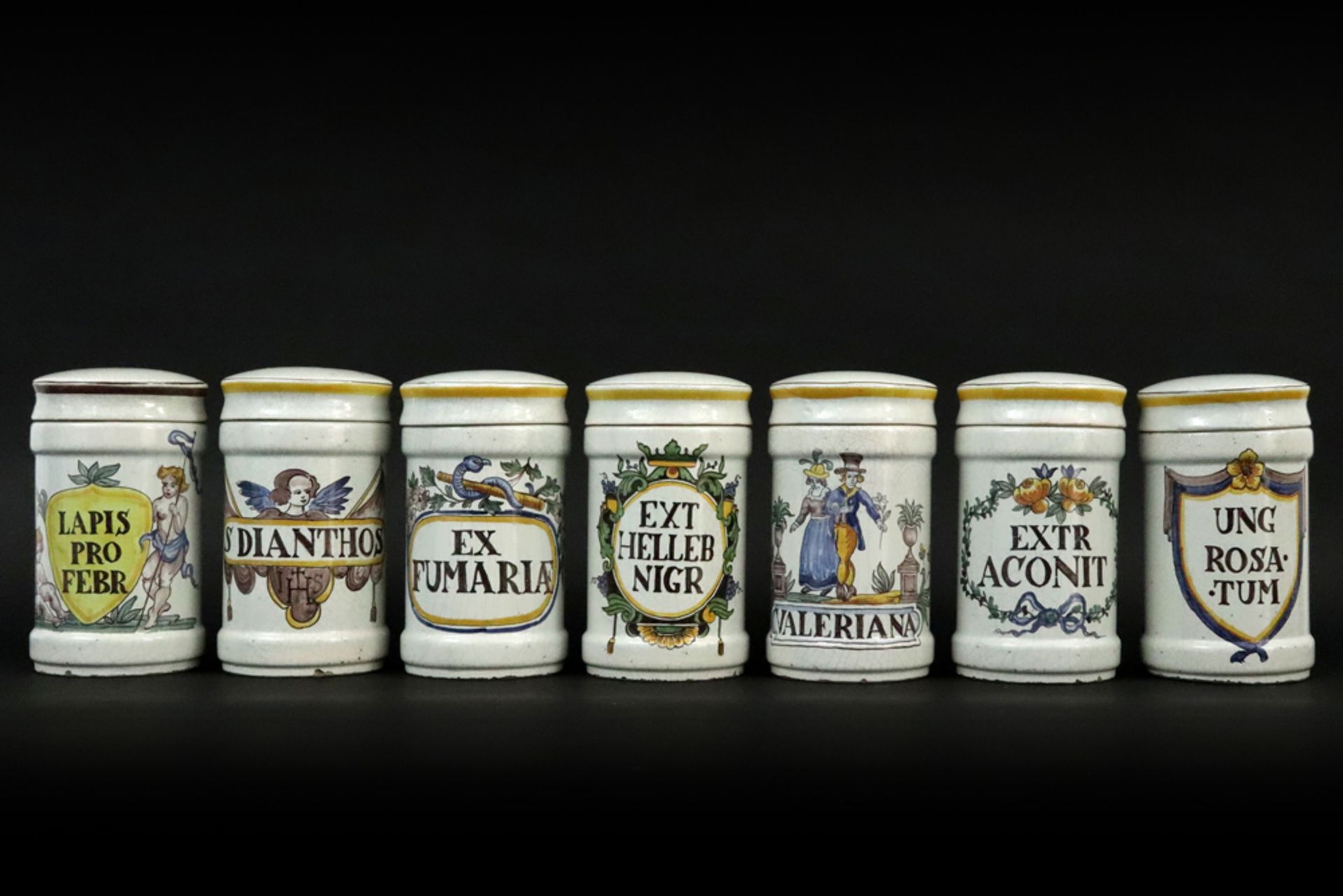 series of seven probably Italian pharmaceutical jars in ceramic with painted decors || Reeks van