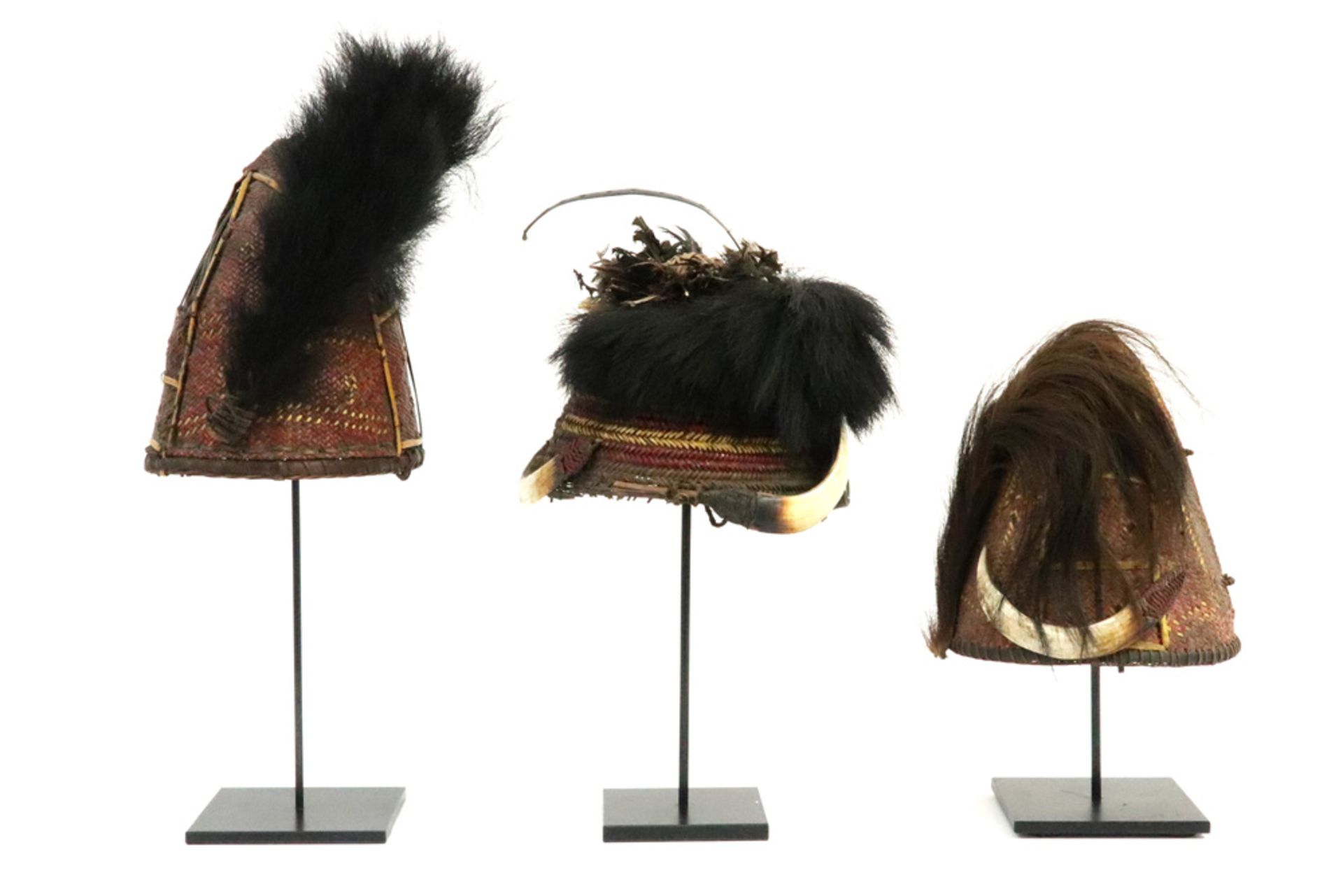 three oriental tribal hats each with tress work and with hair, feathers and/or pig's teeth || Lot - Bild 2 aus 3
