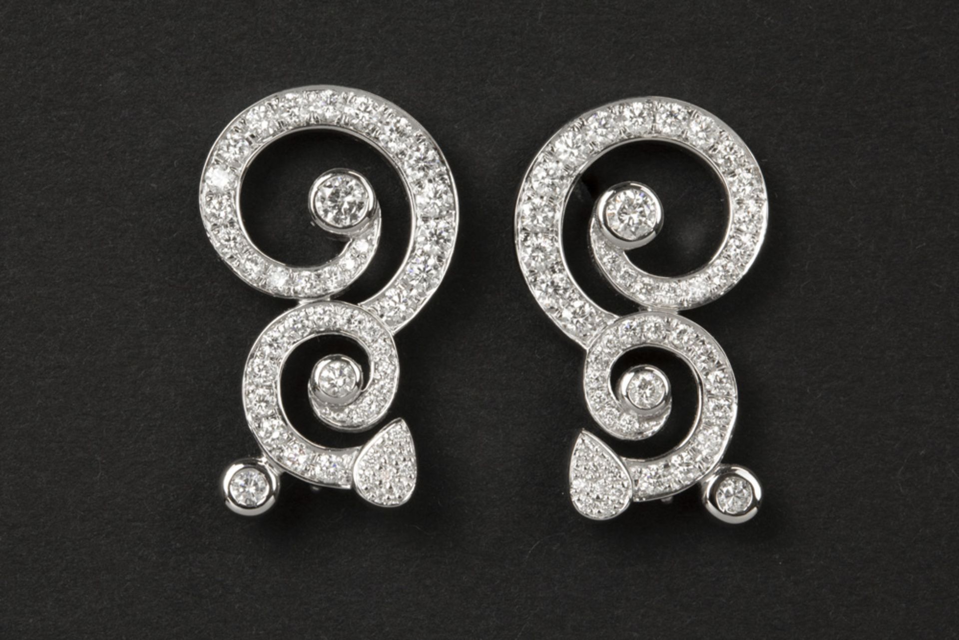pair of earrings with an elegant arabesque design in white gold (18 carat) with ca 1,60 carat of