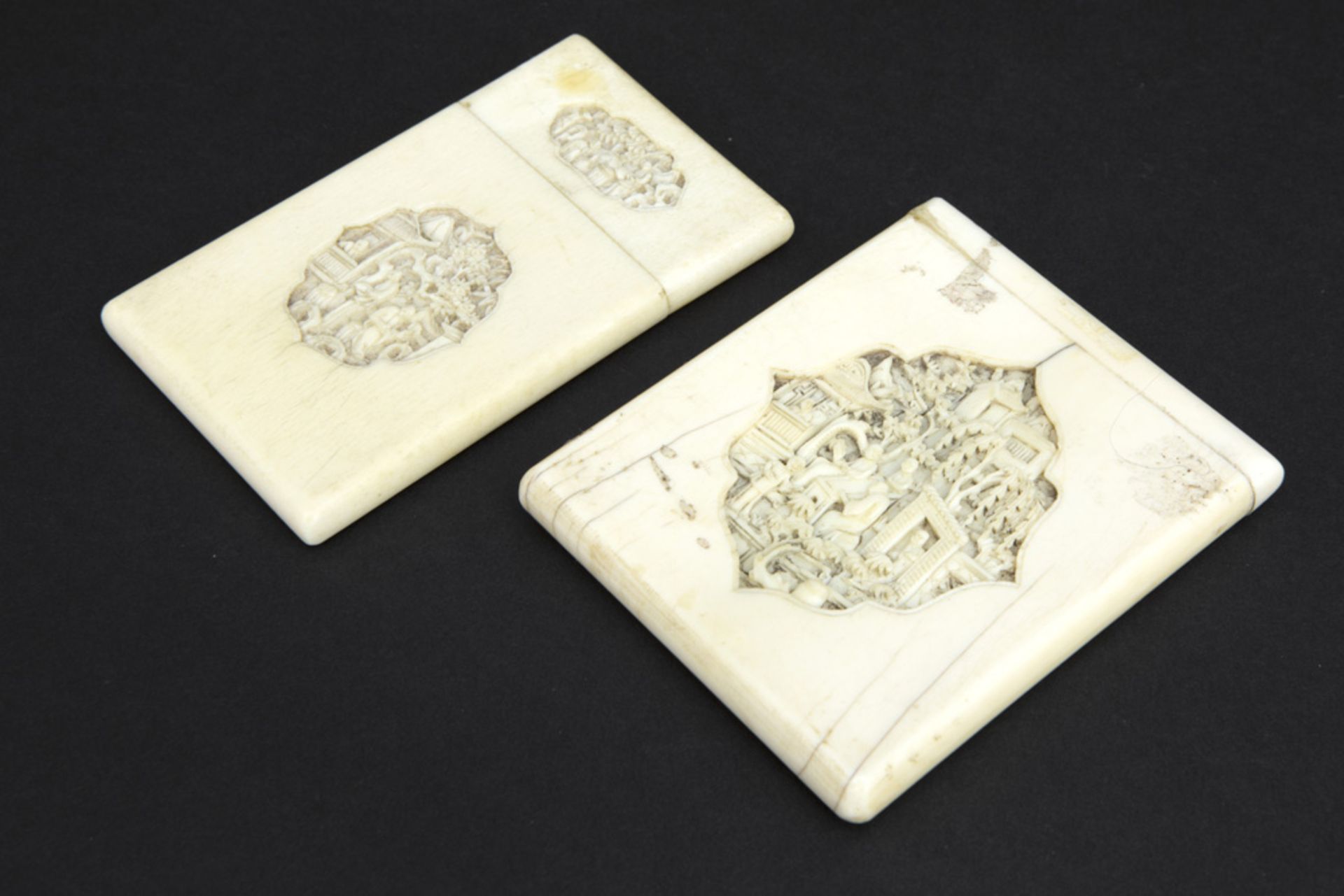 two antique Chinese ivory card cases with finely sculpted scenes with figures || Lot van twee