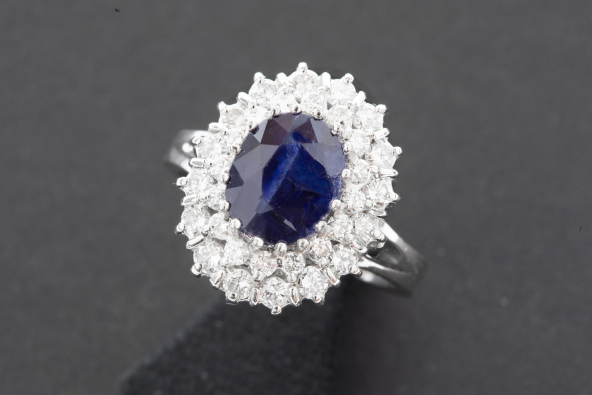 ring in white gold (18 carat) with a ca 2,80 carat sapphire surrounded by ca 1 carat of high quality