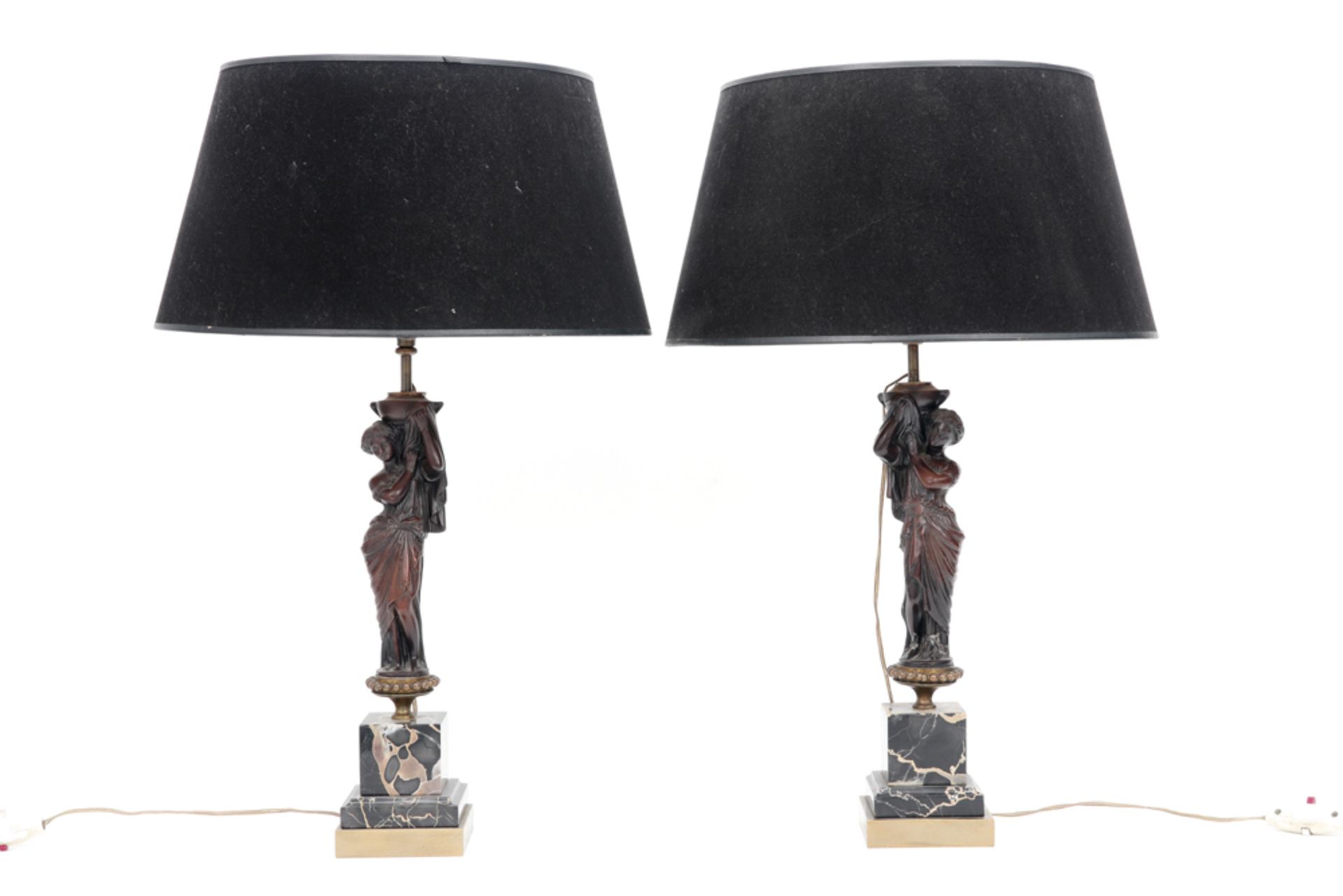 pair of lamps each with an antique sculpture on a marble base || Paar lampen telkens met een antieke