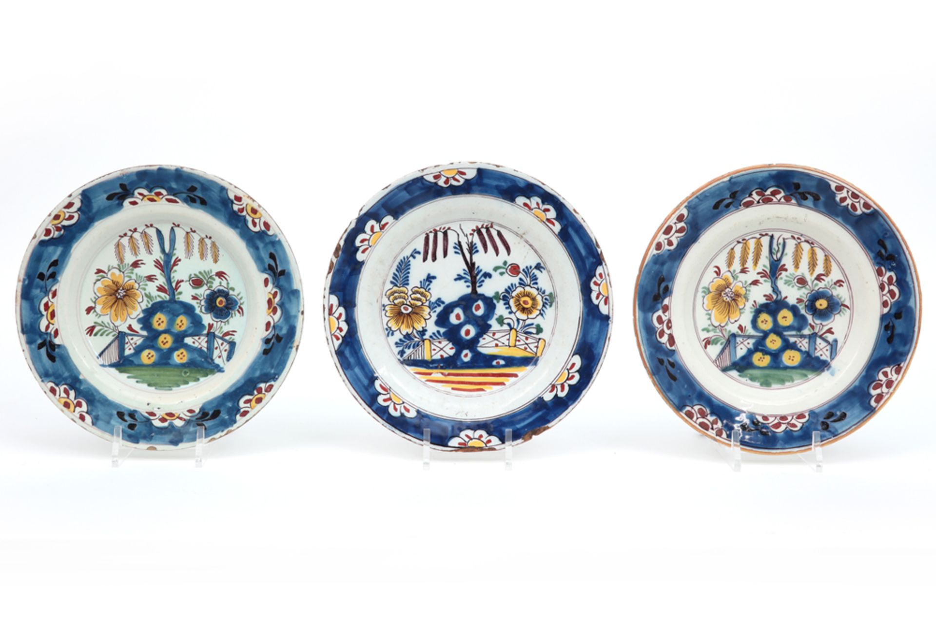 set of three 18th Cent. plates in ceramic from Delft with a polychrome garden decor || Set van