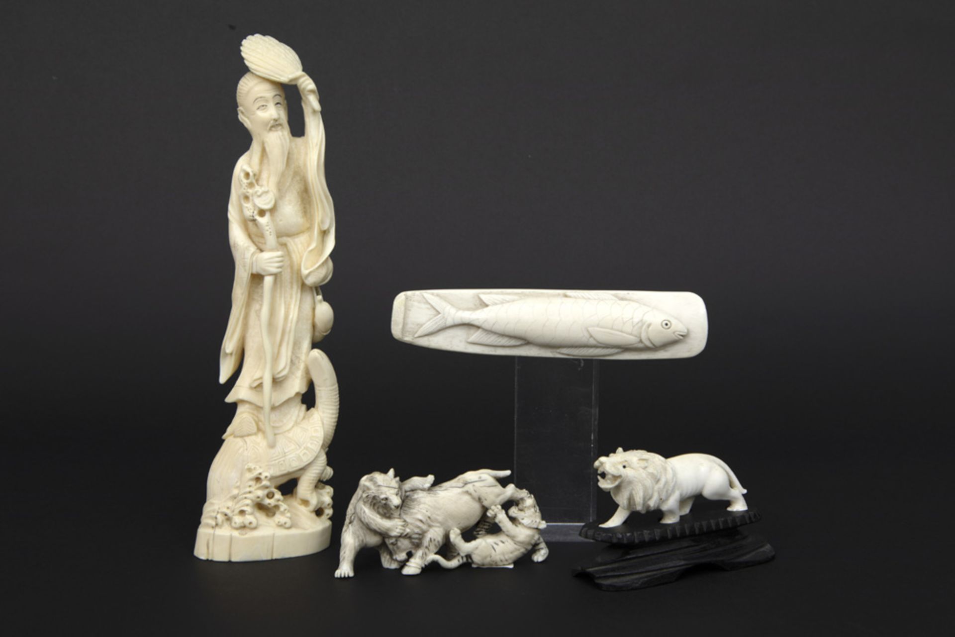 four ivory items amongst which a paperweight (with fish) and "Sage standing on tortoise"