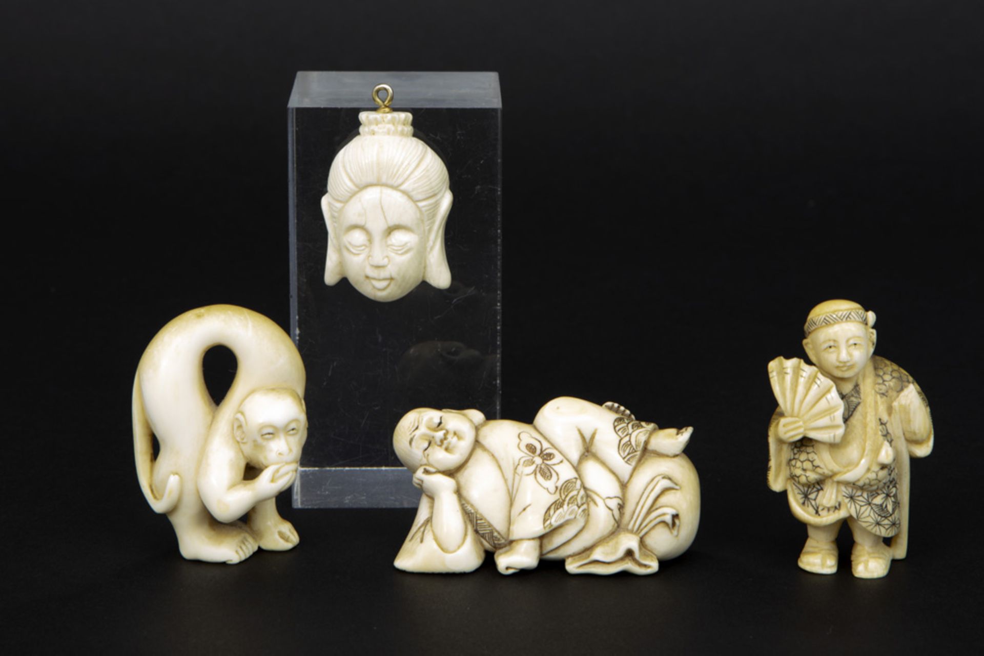 three small sculptures and a pendant in ivory || Lot (4) van drie kleine sculptuurtjes en een hanger