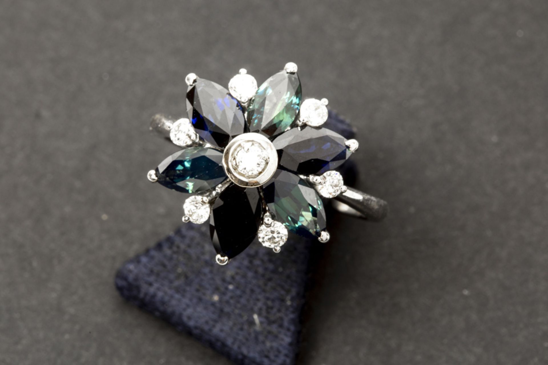 Mooie ring in witgoud (18 karaat) met een bloemvormig sierstuk bezet met ca 3 karaat speciaal geslep