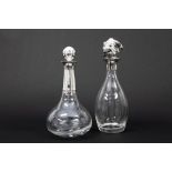 two decanters/claret jugs in glass, one 'novelty' with a monkey's head || Lot van twee karaffen in