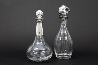 two decanters/claret jugs in glass, one 'novelty' with a monkey's head || Lot van twee karaffen in