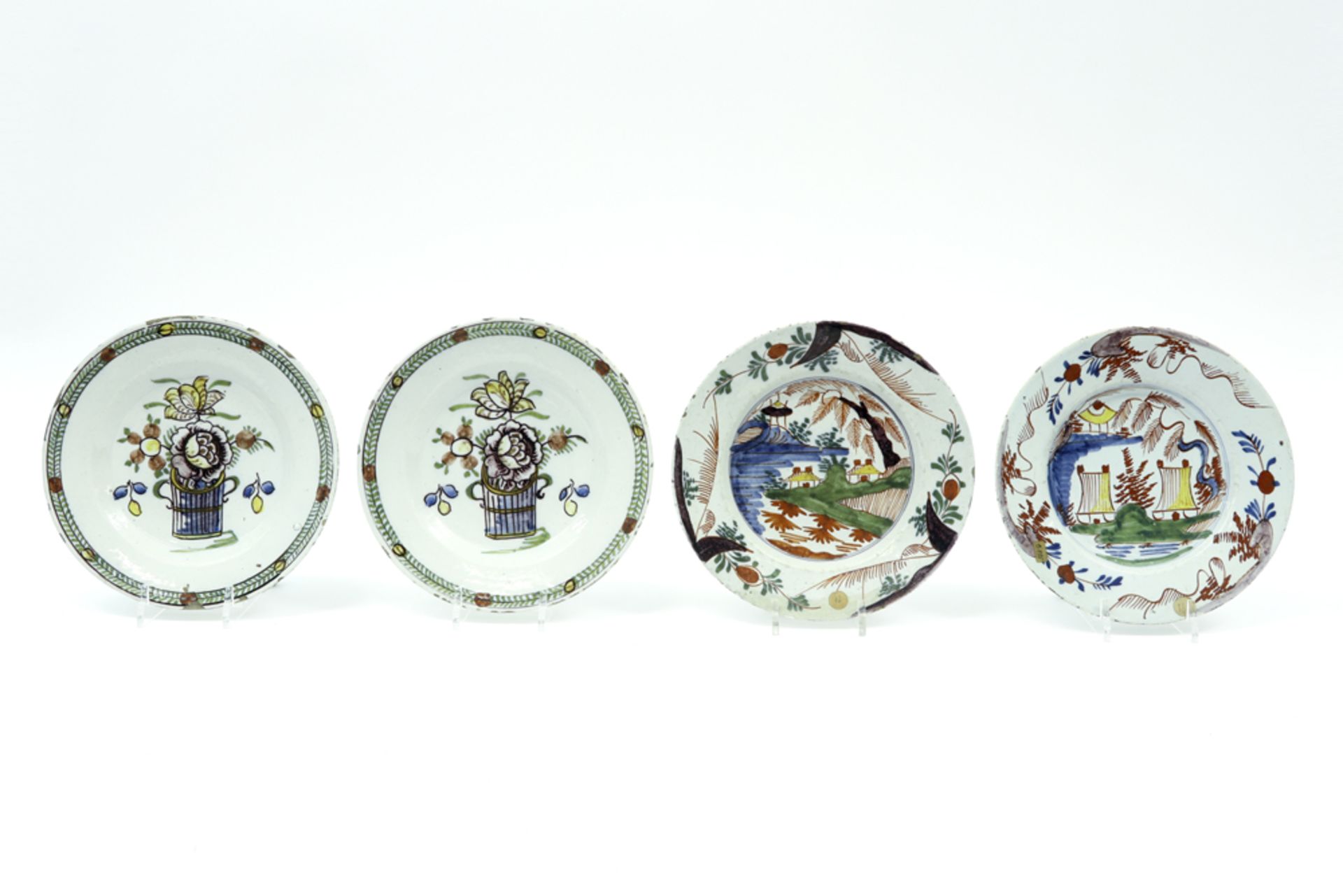 four plates in 18th Cent. ceramic from Delft with polychrome decor || Lot van vier borden in